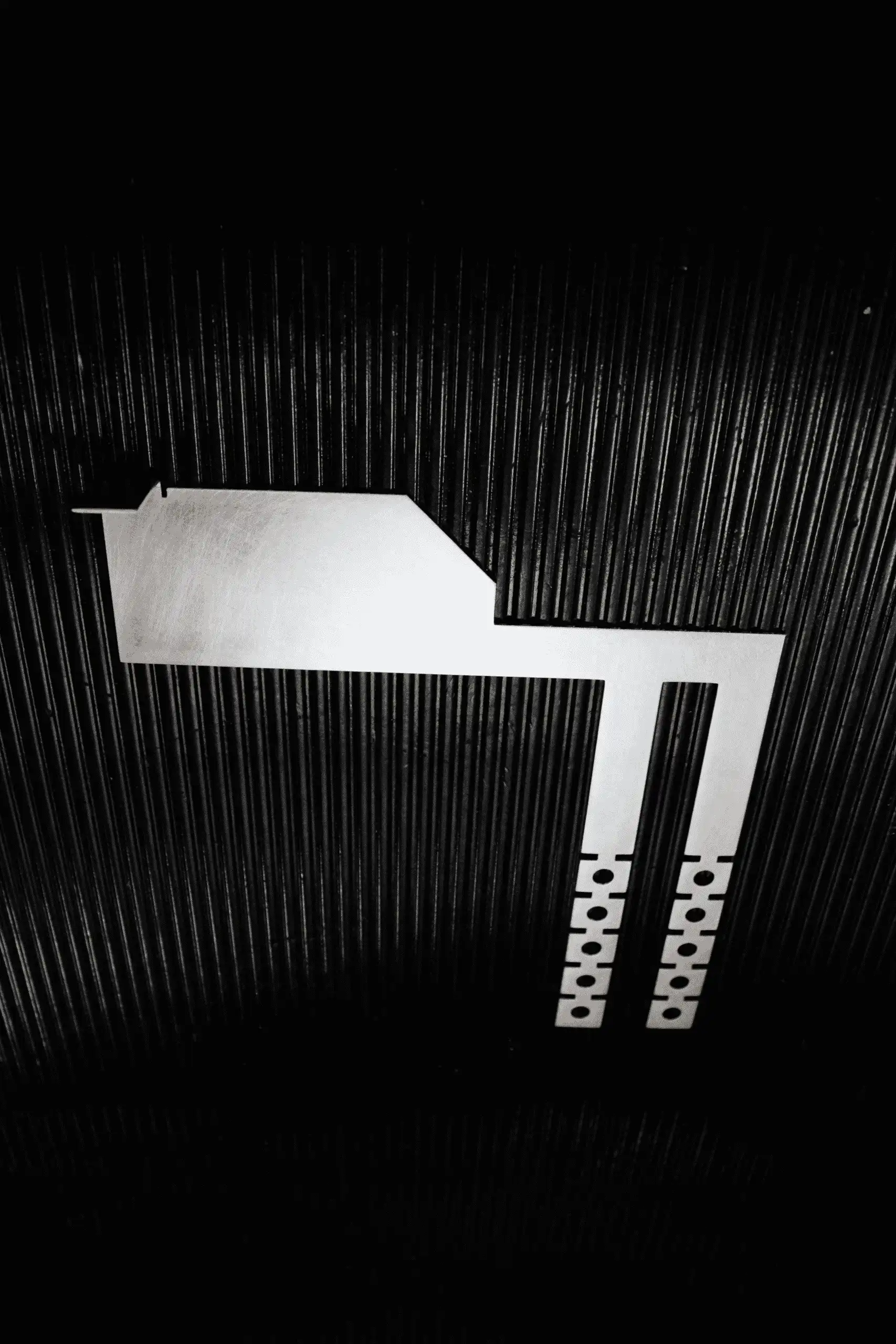 Photo of the Interlockkit adjustable single column breaker retainer on a black background